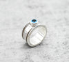  Spinner δαχτυλίδι ασήμι με evil eye πλάγια όψη αριστερά σε γκρι φόντο